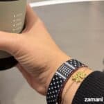 1. Hand holding a coffee cup with a black and white patterned bracelet visible.
